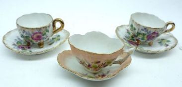A group of three small late 19th/early 20th Century Miniature Cups and Saucers decorated with floral
