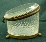 A small round Glass and Brass Mounted Container, raised on three small round feet, 3” high