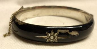 An Edwardian period white metal and black enamelled Bangle with Seed Pearl set star design to the