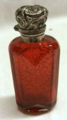 A Victorian facetted Cranberry glass Scent Bottle, rectangular shaped with hinged chased Silver