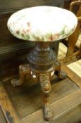 A Victorian Round Topped Adjustable Piano Stool, raised on a heavy oak floral carved tripod base,