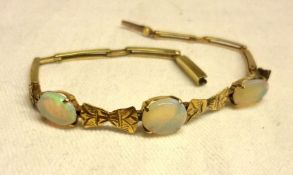 A late 19th/early 20th Century Flexible Link yellow metal Bracelet, set with three Opals (one