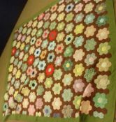 A modern Patchwork Quilt, mostly in colours browns, greens, yellows and titled “Mothers Garden”, 80”