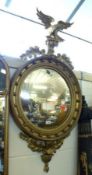 A 19th Century circular Mirror, in round gilded frame with ho ho bird and foliate mount, 23”