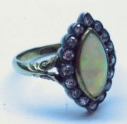 A high grade precious metal Ring with centre Marquise shaped Opal surrounded by sixteen small old
