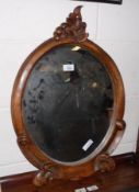 A Victorian Oval Mirror, in stained beech frame, with carved foliage detail, 17” diameter
