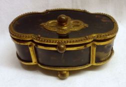 A late 19th Century French gilt metal mounted small Tortoiseshell lidded Box of shaped oval form,