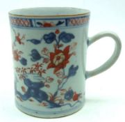 A Chinese Tankard painted in iron red and underglaze blue with flowering foliate design below a