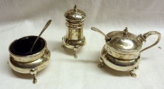 A three piece Condiment Set of compressed circular form, each item standing on three curved feet,