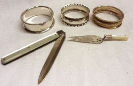 A Mixed Lot comprising: Three small hallmarked Serviette Rings, a Georgian Folding Fruit Knife