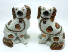 A pair of 19th Century Staffordshire Spaniel, decorated with copper lustre highlights on a white