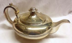 A George IV Teapot of compressed circular form, with reeded raised body band, strap work hollow