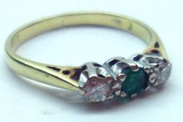 A hallmarked18ct Gold centre small Emerald and two small brilliant cut Diamond Ring