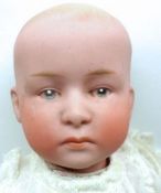 A German Bisque Head Boy Infant Doll with painted eyes, brows and lips, moulded hair detail, over