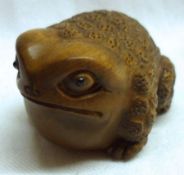 An Oriental carved Hardwood Netsuke of a Toad, 13/4” long