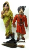 An early 20th Century Composition Head Indian Doll with painted facial features, dressed in