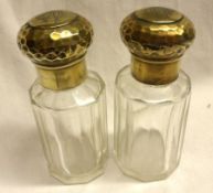 A pair of late 19th/early 20th Century facetted clear glass cylindrical Toiletry Bottles, with