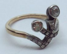 A mid grade precious metal Ring, each stem set with an old cut Diamond