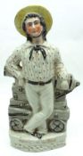 A 19th Century Staffordshire Flatback Figure of a Military Figure resting on a cannon, titled “Ready