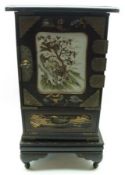 An Oriental Lacquered Table Top Cabinet, the central tiled panel decorated with motif of a tiger