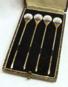 A 1930’s cased set of four plated Cocktail Sticks with enamelled disc finials, inscribed “MAC”, 3 ¼”