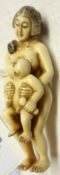 A Japanese carved Ivory Netsuke of a Mother and Child, 2 ½” long, (repaired)