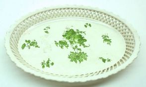 An oval Dish with pierced latticed border and the centre decorated in green with floral sprigs and