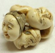 A Japanese carved Ivory Netsuke of six conjoined Noh Masks, 1 ½” wide