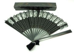 An early 20th Century Fan with black lacquered sticks, central black silk panel edged with Chantilly