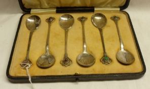 A cased set of six George V large Teaspoons in arts and crafts taste, having spot hammered egg