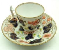 A 19th Century English Cup and Saucer, decorated with blue and iron red foliage with gilt