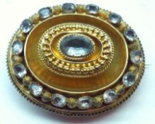 A Victorian mid-grade Gold Oval “Target” Brooch, the raised centre set with an Aquamarine, further