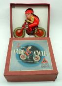 A 1930s Tri-ang Giro Cycle, red celluloid figure mounted on cycle, housed within original box