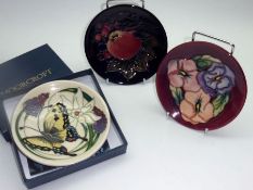 Three Modern Moorcroft Small Circular Plates, each decorated with stylised floral designs, (one in