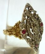 An unmarked precious metal Ring, with marquise-shaped panel, pierced and inset with small Rubies and