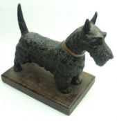 A small Patinated Spelter Model of a Scottish Terrier standing on a treen base, 9” long