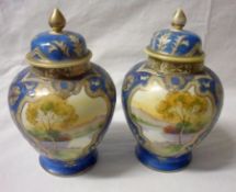 A pair of Noritake Covered Baluster Vases of tapering circular form, painted with panels of lake