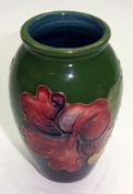 A Moorcroft Small Baluster Vase, decorated with a hibiscus design on a green ground, impressed