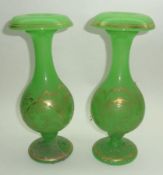 A pair of Decorative French Green Glass balustered Spill Vases, gilded with feathered foliate