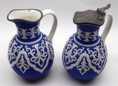 A pair of 19th Century Cobridge Tyrol Jugs, one fitted with pewter lid, the other without, 7 ½” high