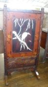 A 20th Century Oriental Carved and Lacquered Fire Screen, inset with a central panel of heron