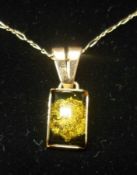 A mid-grade yellow metal small rectangular Pendant, set with Amber-type stone, stamped “.585”,