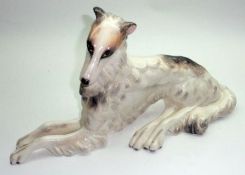 A Wedgwood Model of a reclining dog, decorated in naturalistic colours, 14” long