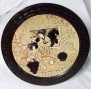 A Bretby Circular Wall Plaque, embossed and decorated with an Oriental interior scene with