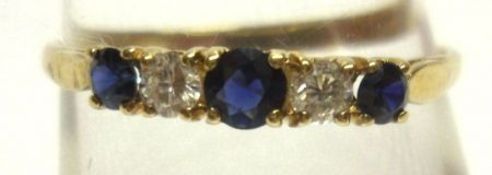 A hallmarked 9ct Gold three small Dark Blue Sapphire and two small Brilliant Cut Diamond