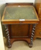 A Victorian Mahogany Davenport, the back with a raised pediment over a green rexine inset and the