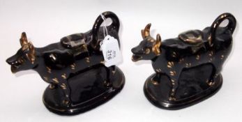 A pair of Staffordshire black and gilded Cow Creamers (slight losses to mouths and horns), 5 ¼” high