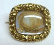 A Victorian Gold Framed Mourning Brooch, of shaped rectangular form, having foliate engraved edge