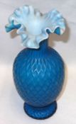 A decorative Vaseline Glass Vase with crimped rim, decorated in shades of blue and also embossed