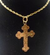 An Edwardian engraved hallmarked 9ct Gold Hollow Cross, 31mm x 21mm and mounted on a trace chain,